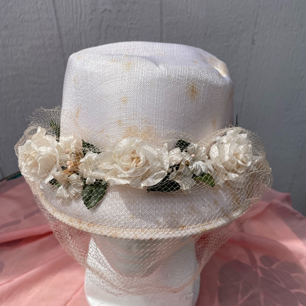 White vintage hat with flowers pinned on